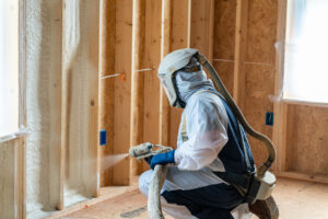 Person spraying white foam on wall