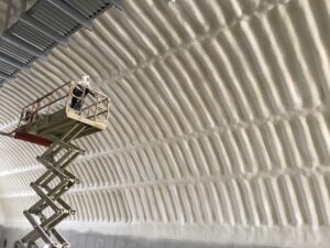 Person on scissor lift spraying foam